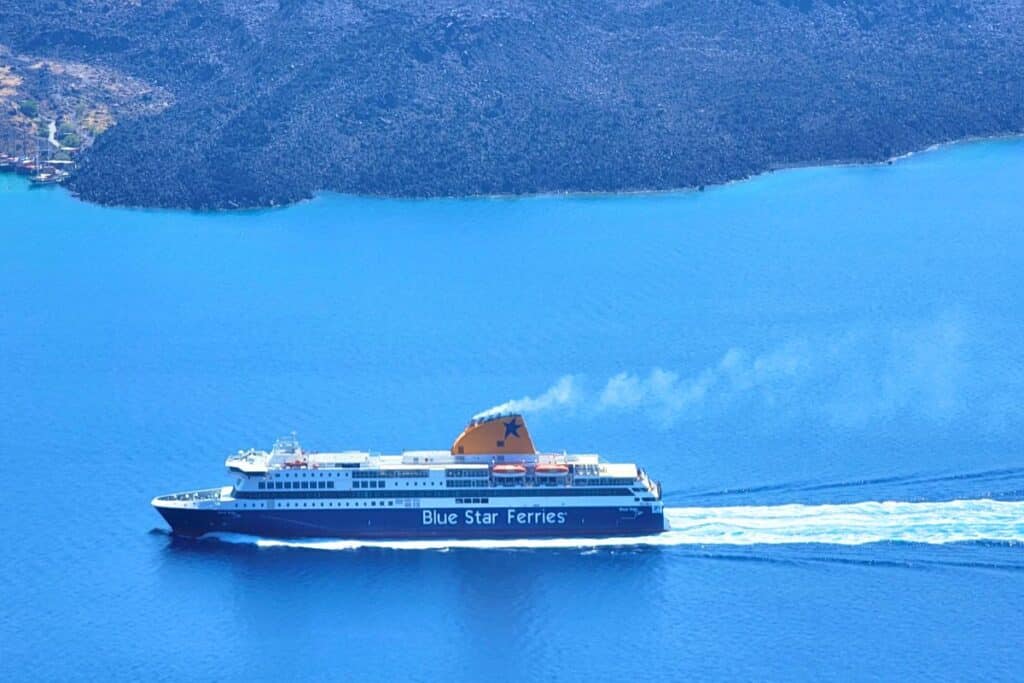 A large car ferry cruises the Aegean Sea past the island of Santorini