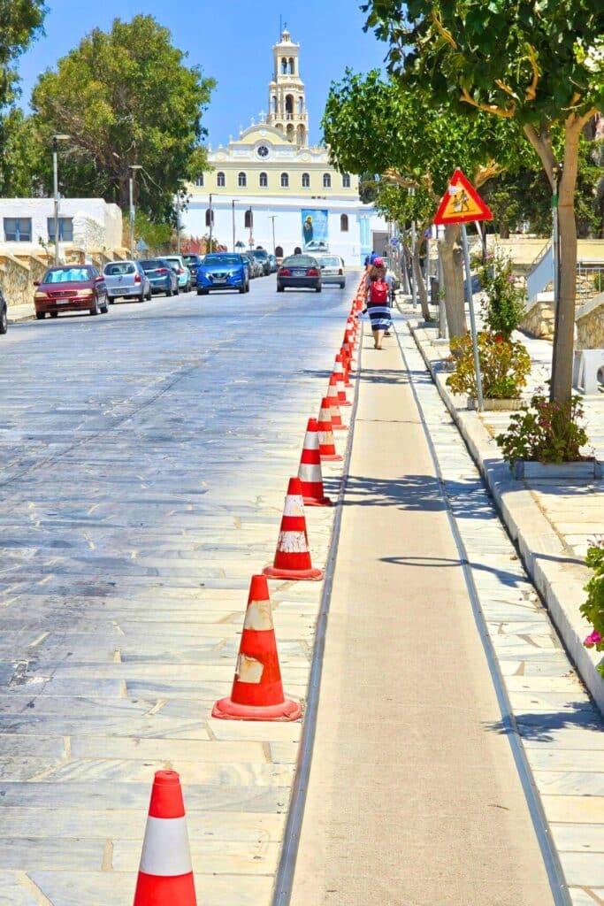 Orange cones line a padded path along the street up to the Tinos church