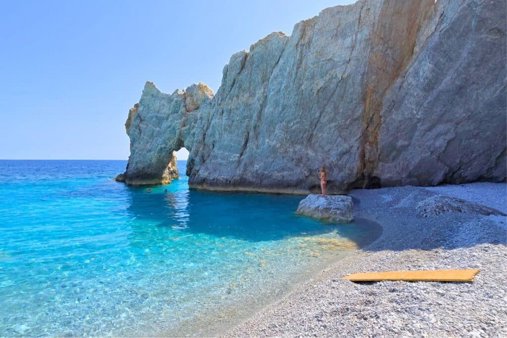 A rock arch over blue sea at Lalaria Beach Skiathos