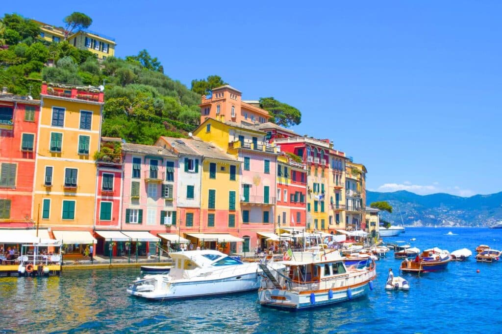 Colorful seaside building line a small harbor filled with boats in Portofino, Italy