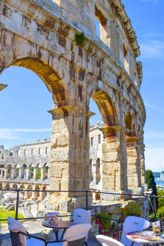 Cafe tables outside the walls of the Pula arena