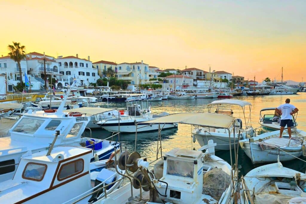 Sunset over an old harbor full of fishing boats in Spetses Greece
